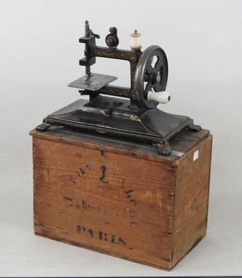 une vieille machine à coudre posée sur une caisse en bois