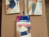 trois boîtes sur lesquelles sont représentés différents types de pansements, posées sur une boîte en carton