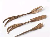 three wooden utensils sitting next to each other on a white surface