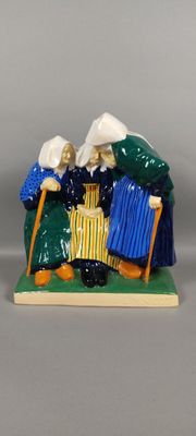 two figurines of people sitting on a bench with umbrellas