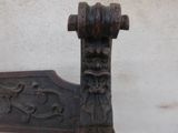 a close up of a wooden bench with a carved head