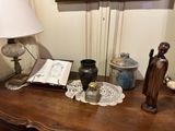 a table with a lamp, a book, a vase, and a book on it