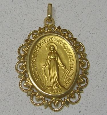 La médaille d'or de la Vierge de Guadalupe est exposée sur un fond blanc.