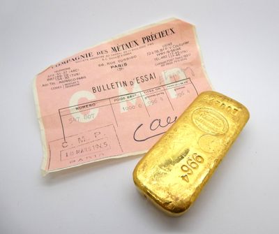 un lingot d'or posé à côté d'un ticket de caisse sur une table