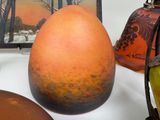 a large orange egg sitting on a table next to a lamp
