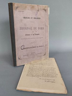 un vieux livre posé sur une table à côté d'une feuille de papier