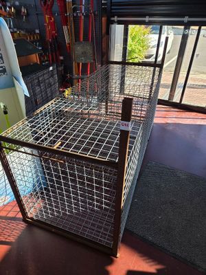a cage that is sitting on the floor next to a surfboard