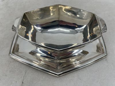 trois plats en argent empilés les uns sur les autres sur une table