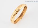 a close up of a gold ring with diamonds on a white background