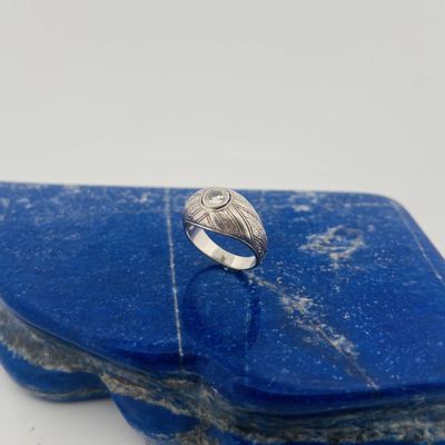 a close up of a ring sitting on top of a blue stone