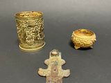 three different types of brass items are displayed on a black surface