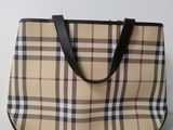 burberl and black checkered purse on a white surface