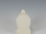 a white candle holder with a small house on top of it