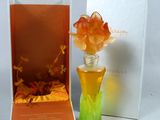 un vase en verre contenant une fleur, posé à côté d'une boîte