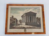 an old picture of a building in a wooden frame hanging on a wall