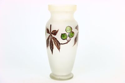 un vase blanc orné de feuilles vertes sur fond blanc