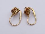 two pairs of gold earrings with brown stones on a white surface