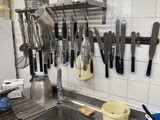 a kitchen with a sink and a lot of utensils hanging on the wall