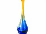 a blue and yellow vase sitting on a white surface
