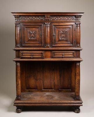 an antique oak cupboard with carved panels and drawers