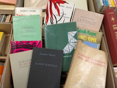many books that are in a box on the floor