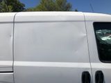 a white van parked in a parking lot with trees in the background