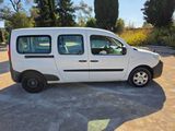 the small white van is parked in the parking lot