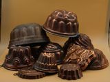 de nombreux gâteaux au chocolat en forme de bundt posés sur une table, surmontés d'un chapeau
