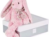 lapin en peluche rose posé dans une boîte-cadeau sur fond blanc