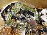 a pile of assorted jewelry on a wooden table