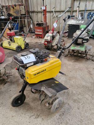 de nombreuses tondeuses à gazon et autres équipements de jardinage dans un garage