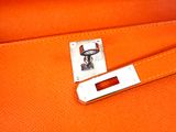 an orange leather bag with a metal latch on the handle