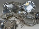 de nombreux plats et plateaux en argent posés sur une table