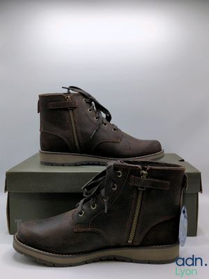 men ' s brown leather boots with zippers and laces on top of a box
