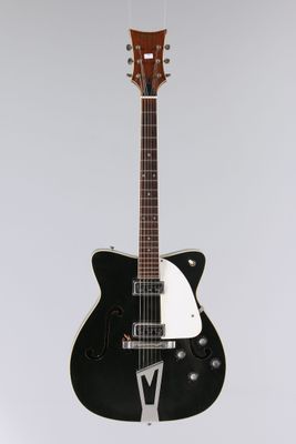 une guitare électrique noire et blanche accrochée au mur