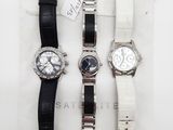 trois montres sont posées sur un tissu blanc, avec une étiquette de prix