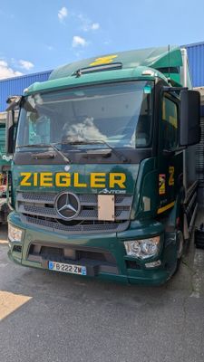 un camion vert garé devant un immeuble