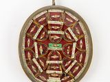 une image représentant une horloge rouge et dorée sur laquelle figurent des mots