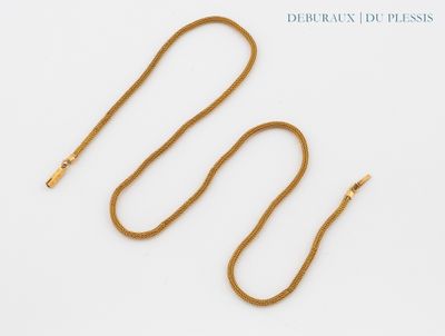 a close up of a gold chain on a white surface