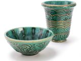 two green bowls sitting next to each other on a white surface