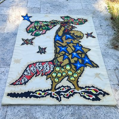 un tapis blanc sur lequel est représenté un oiseau perché sur un trottoir