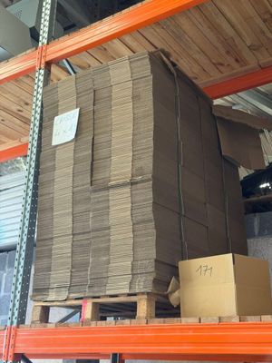 une grande pile de cartons posée sur une étagère dans un entrepôt