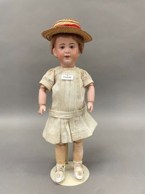 une image représentant une petite poupée avec un chapeau de paille et une robe
