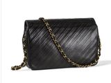 a black leather bag with a chain strap and a gold clasp