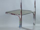 une photo d'une table d'appoint en chrome et en verre sur fond blanc