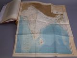 an old map of india on a table with an open book