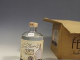 a bottle of alcohol sitting next to a box on a table
