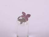a close up of a pink butterfly ring on a clear glass