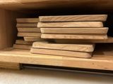 a stack of wooden boards on a shelf in a kitchen