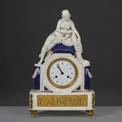 une horloge blanche et bleue surmontée d'une statue